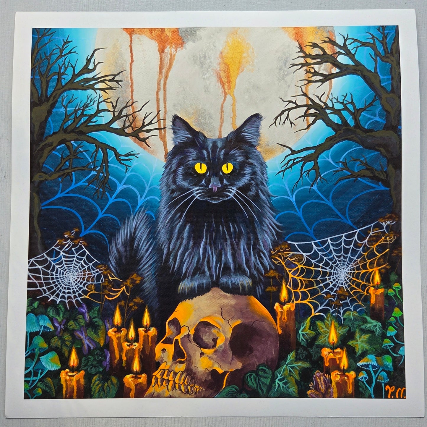 Black cat with yellow eyes in a Halloween-themed setting with candles, skulls, and spider webs.